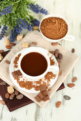 Cocoa powder in cup on napkin on wooden table