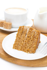 piece of honey cake on a plate and cup of cappuccino