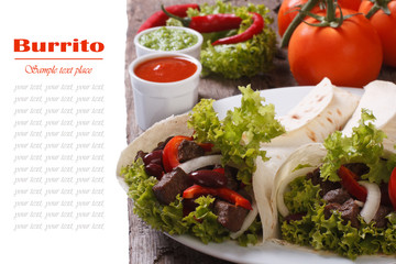 burrito with meat and vegetables and sauce isolated on a table