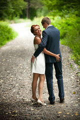 Obraz premium Newly married couple walking in park and laughing