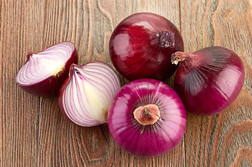 Fresh red onions on a wooden background
