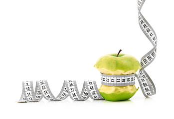 white measuring tape and apple