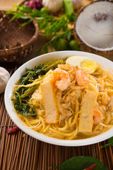 Prawn Laksa soup with rice noodles, shrimps garnished with fresh