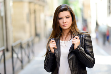 Beautiful japanese woman in urban background wearing leather jac