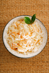 sauerkraut - Sour cabbage -  enamel bowl with bay leaves