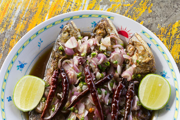 Salted fish fried in a white plate on the table