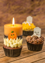 Halloween cupcakes and candle on a wooden table