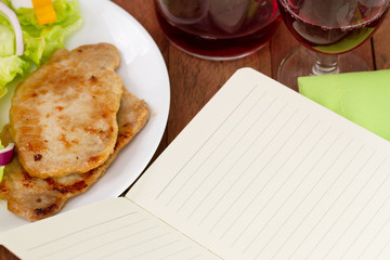 notebook with plate of fried pork