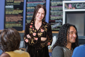 Cute Woman with Folded Arms in Cafe