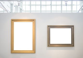 Two empty picture frames on white wall