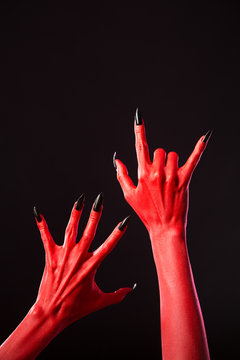 Red devil hands with long black nails, real body-art