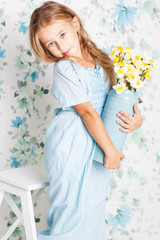 Little cute girl in blue dress in studio