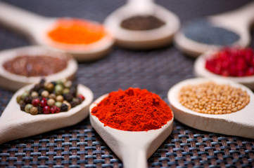 Various kind of spices on wooden spoon -  detail of chili powder