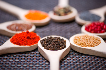 Various kind of spices on wooden spoon -  detail of black pepper