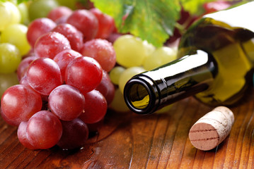 bottiglia di vino vuota con grappolo di uva rossa