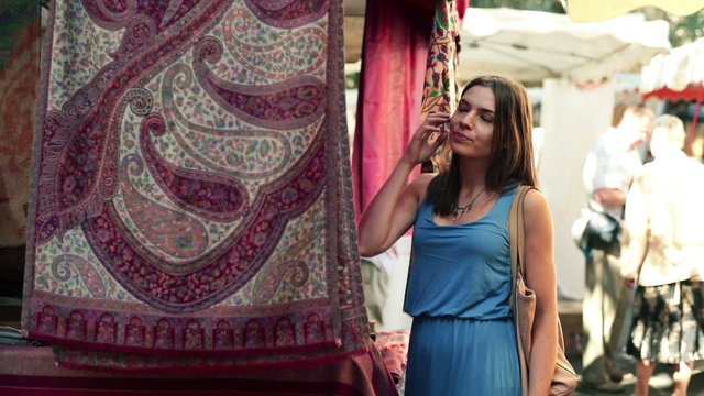 Woman looking at beautiful carpet at city market