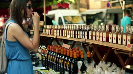 Young woman tasting food sample on city market