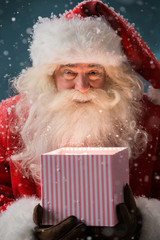 Portrait of happy Santa Claus opening gift box