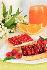 Delicious toast with cranberries on table on light background