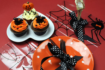 Happy Halloween party table cupcakes on red background