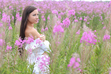 young woman in a white dress on a background of tall grass