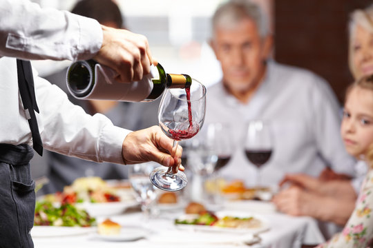 Kellner gie&szlig;t Wein in ein Glas