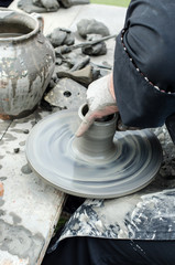 Close-up of hands making pottery from clay on a wheel.