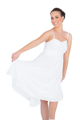 Fototapeta na wymiar Cheerful beautiful young model in white dress dancing