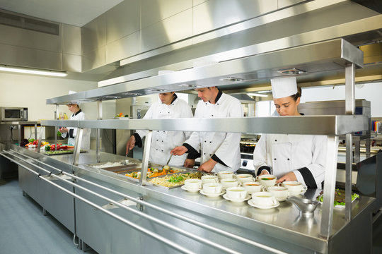 Four Chefs Working In A Big Kitchen