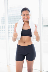 Confident dark haired model in sportswear giving thumbs up