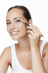 Fototapeta premium Portrait of young woman applying eye shadow