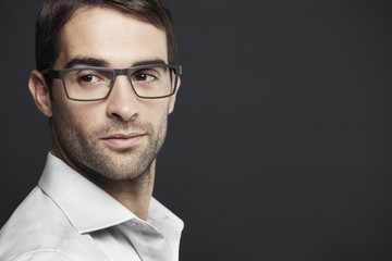 Portrait of mid adult man wearing glasses, looking away