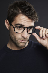 Mid adult man adjusting glasses, studio shot