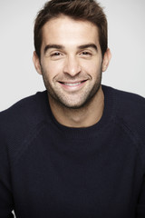 Fototapeta premium Portrait of mid adult man against grey background, smiling