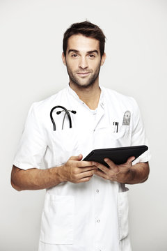 Portrait of mid adult doctor holding tablet