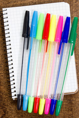 Fototapeta premium Colorful pens and spiral notebook