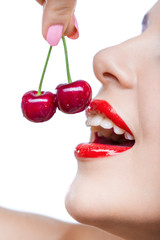 Close up of young girl with red lips eating two berries - 56986249