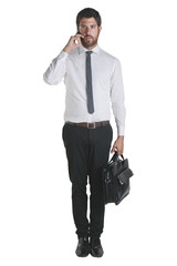 Businessman standing with briefcase and talking with smartphone.