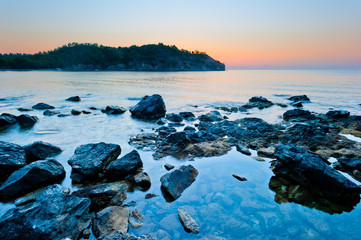 rocky bottom of the sea and the sunrise over the mountains