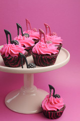 Female high heel shoes on pink and black cupcakes