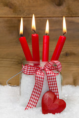 Vier rote Kerzen mit Herz als Weihnachtskarte mit Holz rustikal