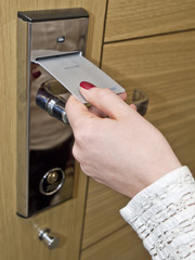 Hotel door - hand inserting key card in an electronic lock