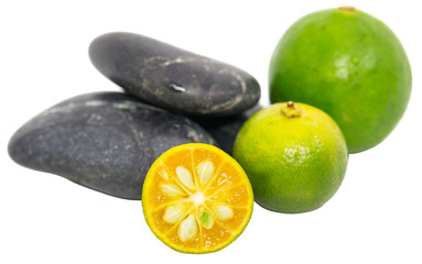 Calamondin, lime and zen stones over white background