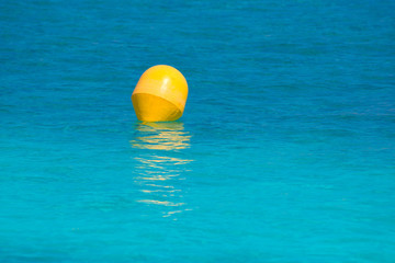 Yellow buoy floating in Mediterranean turquoise sea