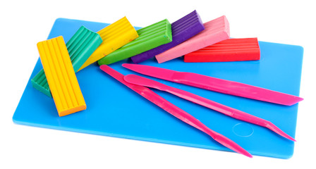 Children bright plasticine on desk with stacks isolated on