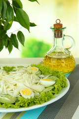 Delicious salad with eggs, cabbage and cucumbers on table