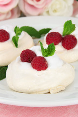 Tasty meringue cakes with berries, close up