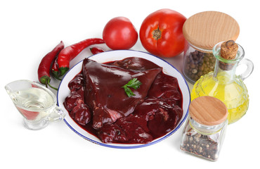 Raw liver on plate with spices and condiments isolated on white