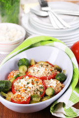 Stuffed tomatoes in bowl on wooden table close-up