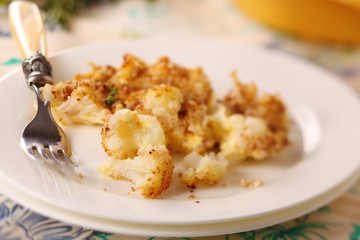 Baked cauliflower with cheese and nuts on a plate.